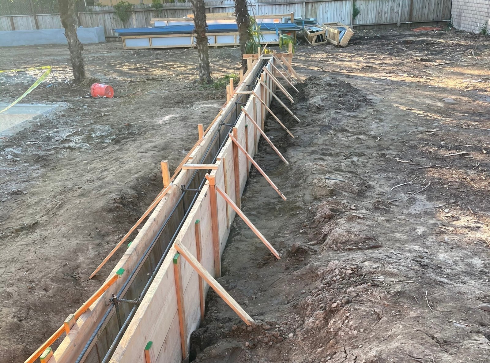 Wood concrete forms staked along a trench before the pour