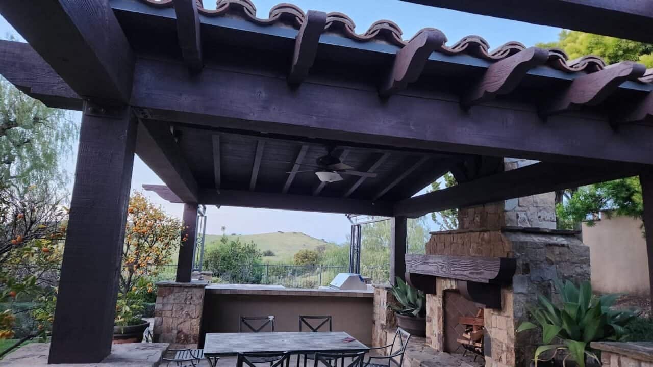 Large sized pergola with a barbeque grill, lights, and a fire place.
