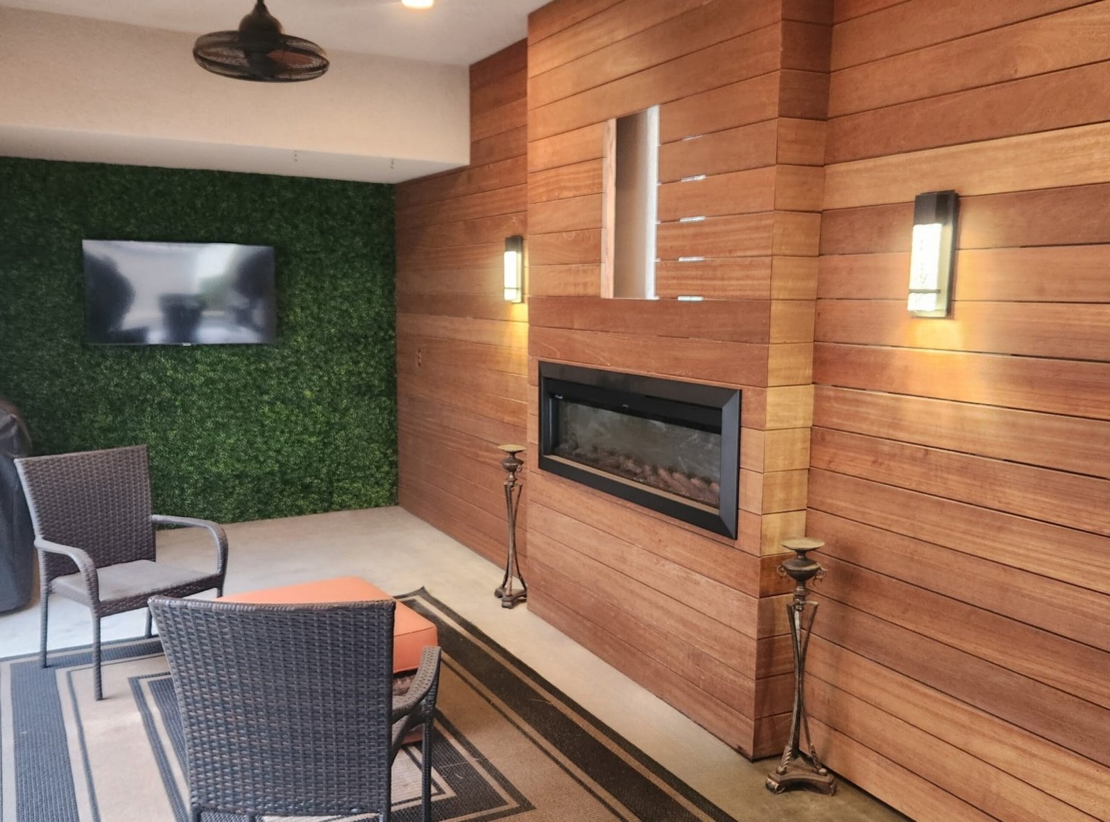 Wood plank accent wall with built-in fireplace on a covered patio