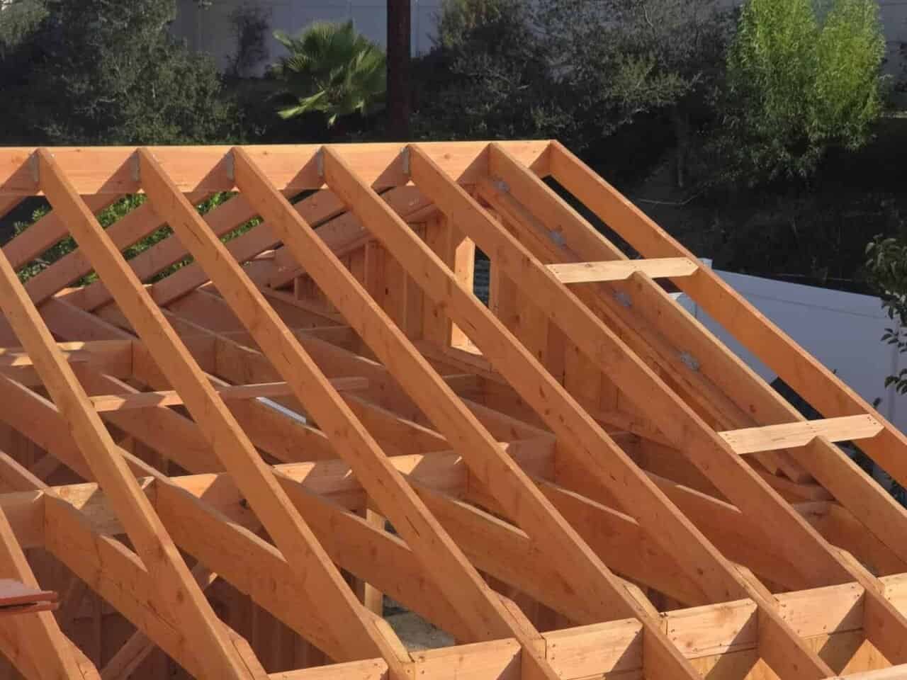 Room addition roof framing by OC Renovation Group in Orange County — rafters, ridge beam, and Simpson Strong-Tie hardware installed to California code